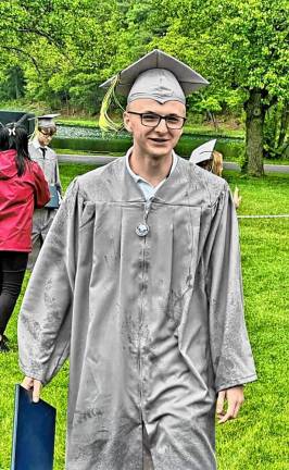 Nick Holowach holds his diploma.