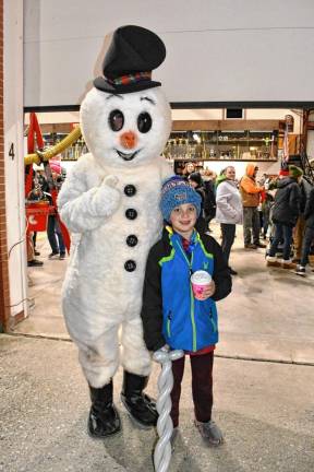 <b>Kenneth Peterson poses with a snowman.</b>