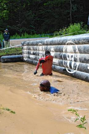 <b>Spartan Race competitors go through a series of deep water-filled mud pits.</b>