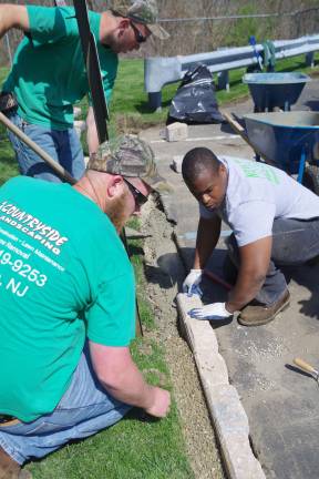 Project coordinator Jay Meerendonk of Countryside Landscaping (left) and Alastair Williams of New Magic Landscaping check the alignment of the paving stones.