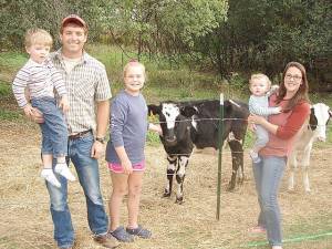 The Touw family stopped working long enough to pose for a family portrait. From left: Jason Touw, holding his son, Owen, 4; daughter Baylie, 12; and Kristin, holding son, Emmett, 16-months old. With them are two eight-month-old calves that Baylie just adores, along with her two rabbits, which she’s often seen carrying around in a basket. Baylie is already a big help on the farm. Missing from the photo is seventeen-year-old Samuel, who was working at the time.