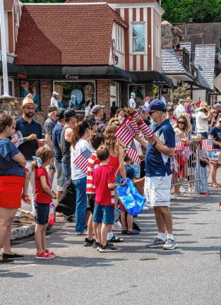 Sparta Councilman Daniel Chiariello hands out flags to the parade watchers. (Photo by Nancy Madacsi)