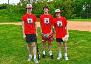 DA1 Connor Prout, Joe Elko and Brady Conklin, all of Sussex, wear T-shirts with a photo of Dolson ‘Doc’ Ayers Sr. at the first Doc Ayers Charity Game on Sunday, May 19 at High Point Regional High School. The money raised will go to a scholarship in memory of Ayers, who helped coach the school’s baseball team for 24 years. (Photos by Maria Kovic)