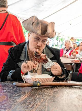 Barbaras Kaynak eats a turkey leg.