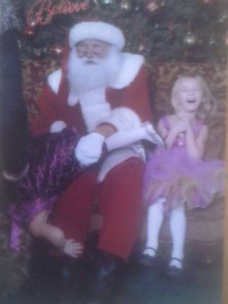 Submitted by: Randi Slamiak of West Milford, N.J. &quot;My daughter was terrified of Santa. She tried to get away. This is my favorite Christmas picture. I leave it out all year. Both santa and sister laughed so hard.&quot;