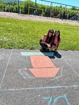 Janely Zayas, 34, and her daughter Jaliann Castillo, 12, draw Snoopy on his doghouse.