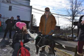 Bill Epperly’s service dog, Panda, greets Marissa DeOliveira. (Photo by Becca Tucker)