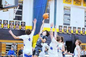 <b>Vernon's Alex Fessel, center, takes a shot surrounded by Warren Hills defenders in the first half of their game Saturday, Dec. 21. The Vikings won, 63-55. (Photos by George Leroy Hunter)</b>