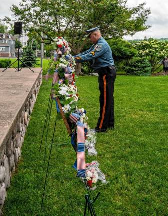 A Sparta police officer places a wreath during the ceremony. (Photo by Nancy Madacsi)