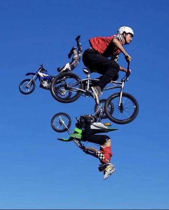 <b>Johnny Rockett’s Cycle Circus’ freestylers fly throught the sky.</b>