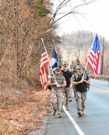 <b>Veterans march with flags and rucksacks from Mountain Creek to the Wallkill Valley Veterans of Foreign Wars Post #8441 in Vernon on Veterans Day, Monday, Nov. 11. (Photo by Maria Kovic)</b>