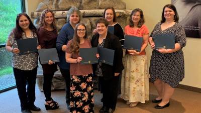 Participants from the most recent HOW graduating class at Project Self-Sufficiency display their certificates of achievement