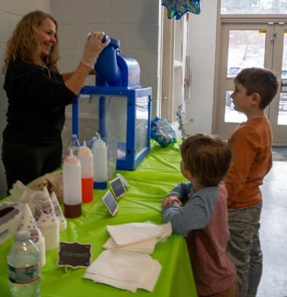 Edith Lynch makes snow cones for Johnathan and Caleb Ahearn.