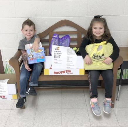 Pictured are Logan Yuhas and Brooke Collura from Ms. Roy's Kindergarten class helping with the items already collected.