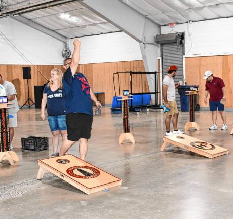 <b>Dinner guests play cornhole.</b>