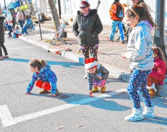 Children pick up candy thrown by people in the parade.