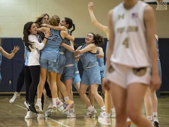 As the timer ends the tournament’s final game against Pope John, Sparta team members gather for a group hug.