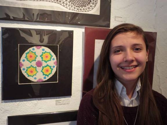 Artist Felicia Kurish next to her creation called &quot;Many Suns&quot; which is made with sand. Kurish is a seventh grade student at Immaculate Conception Regional School in Franklin.