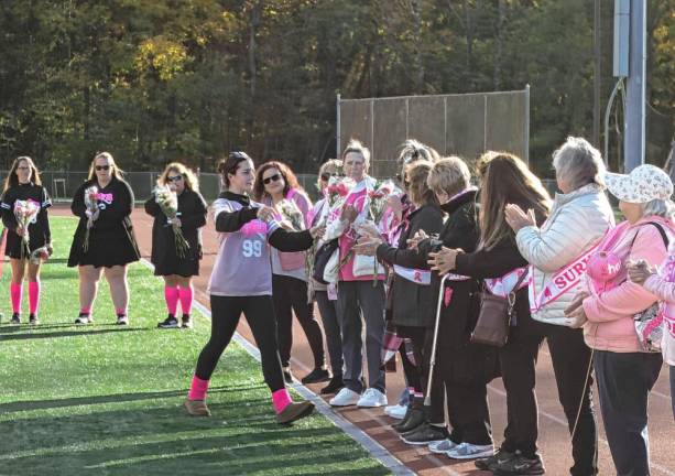 <b>PC2 A player presents flowers to a breast cancer survivor at the game.</b>