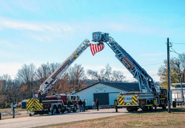 <b>A flag hangs from Newton and Sparta firetrucks at the Sussex County fairgrounds.</b>