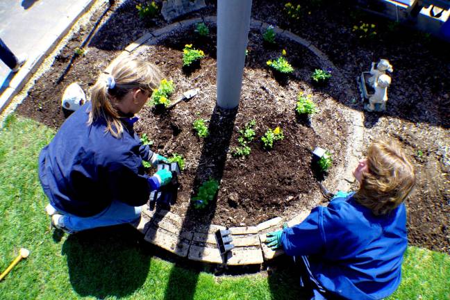 From left, Margaret Kranz of Valley National Bank and Cindy Rourke of the Vernon PAL plant pansies donated by Heaven Hill Farm.