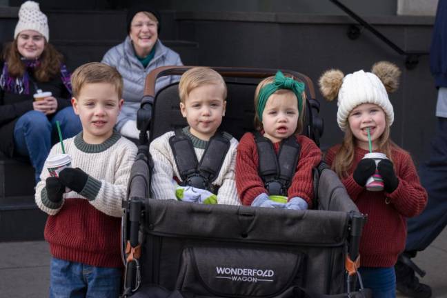 Watching the parade are two sets of twins in the Van Curen family of Augusta. From left are Vinnie, 3; Dominic and Lexi, both 1; and Allison, 3.