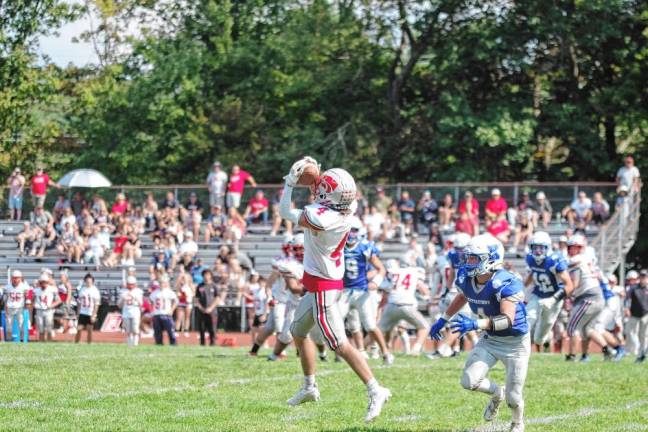 <b>High Point wideout Caden Nardone catches the ball while shadowed by Kittatinny defensive back Niko Martinez in the second half. The Wildcats defeated the Cougars, 36-21, in their third win in a row. (Photo by George Leroy Hunter)</b>