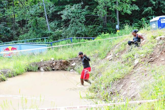 <b>Spartan Race competitors go through a series of deep water-filled mud pits.</b>