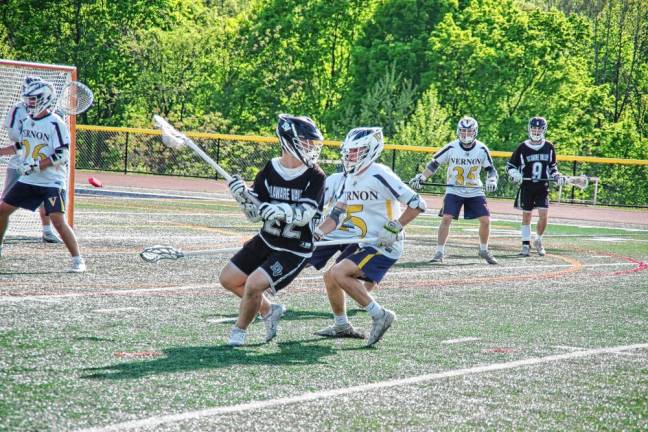 While in possession of the ball, Delaware Valley's Peyton LaRocco (22) is shadowed by two Vernon defenders. The junior scored the 200th goal of his career.