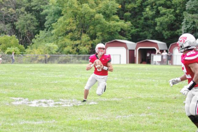 <b>High Point quarterback John Elko looks down field for an open receiver. He scored one rushing touchdown.</b>