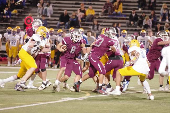 In the first half, Newton quarterback Matt Elsworth runs with the ball in heavy traffic. He threw one touchdown pass in the game against Lyndhurst.