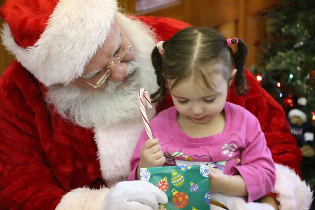 Santa gives Aubrie Strick of Wantage a goodie bag while listening to her wish list.