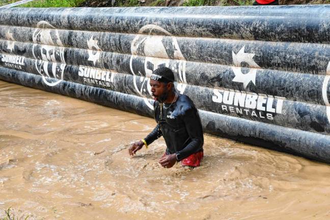 <b>Spartan Race competitors go through a series of deep water-filled mud pits.</b>