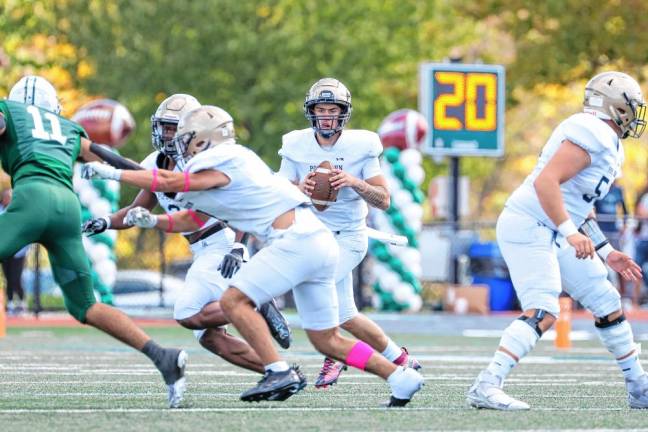 <b>Pope John quarterback Luke Irwin looks downfield as his offensive line provides protection from the Delbarton defenders. (Photo by Glenn Clark)</b>