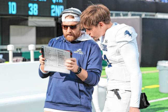 Lions quarterback Luke Irwin listens to offensive coordinator Brian Gibbs on the sideline during the first half.