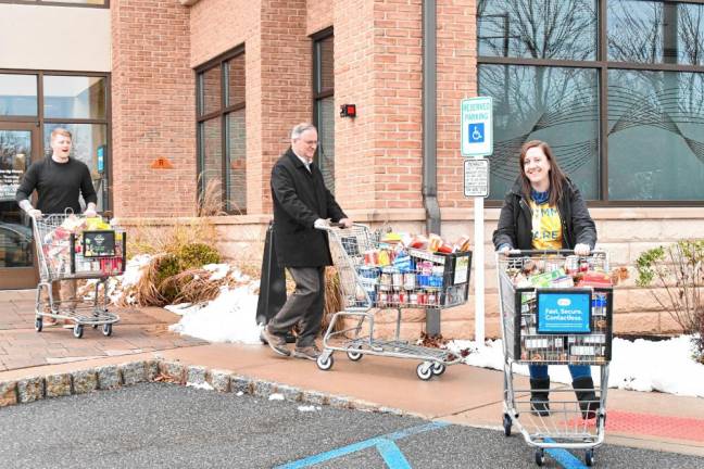 Provident Bank employees bring donated food to a Sussex County Skylands Ride bus as part of the ‘Stuff the Bus’ food drive.