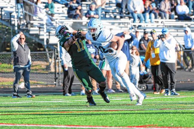 <b>Sparta running back Brady Shagawat uses a stiff arm against a Montville defender on a second-half drive. (Photo by Glenn Clark)</b>