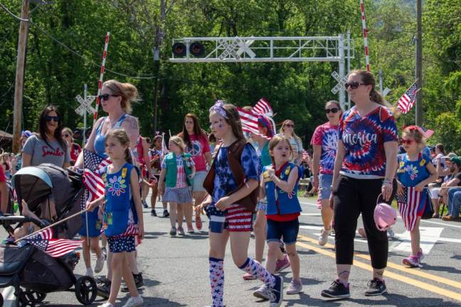 Northern New Jersey Girl Scouts join in the parade, wearing red, white and blue head-to-toe and waving American flags.