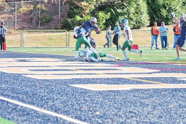 <b>In the second half of the game against Camden Catholic on Saturday, Nov. 9, Pope John ball carrier Tylik Hill makes it to the end zone, dragging defenders with him for a touchdown. The Lions won, 42-7. (Photo by George Leroy Hunter)</b>