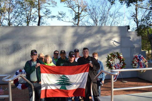 Beirut veterans hold a flag in front of the memorial to those killed in the Marine barracks bombing during a reunion at Camp Lejeune, N.C., in 2018.