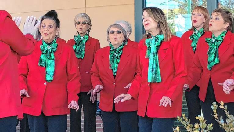 The a cappella group Harmony in Motion sings carols at the event.