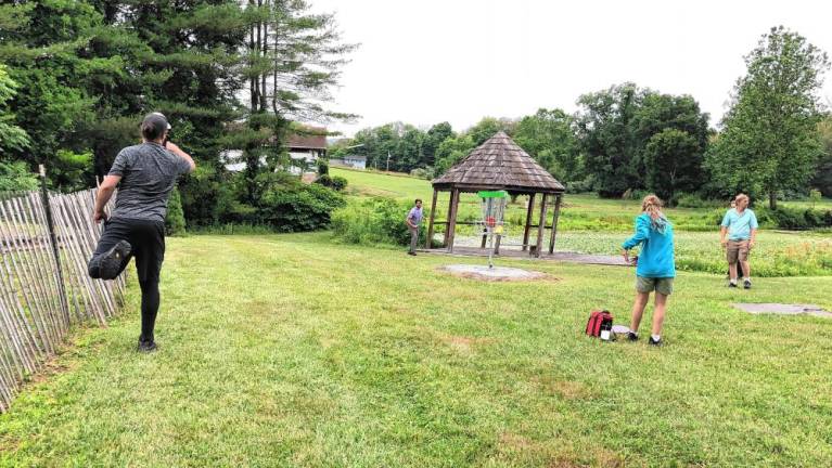 <b>Residents practice before the disc golf tournament begins.</b>