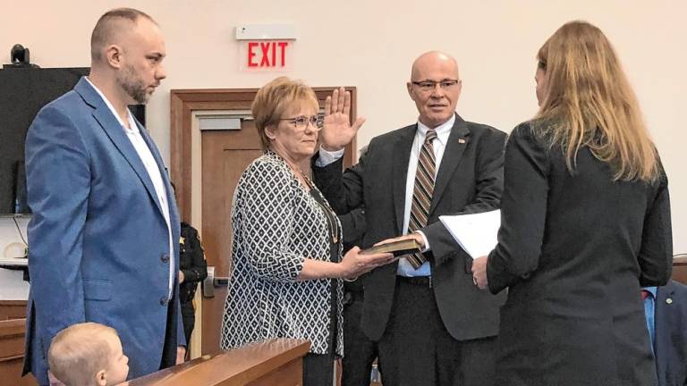 Former Lafayette Mayor Alan Henderson takes the oath of office as a member of the Sussex County Board of County Commissioners on Wednesday, Jan. 1. From left are his son, Andrew; his wife, Lorie; and his daughter, Vanessa Henderson-Aikens, who administered the oath. (Photo by Kathy Shwiff)